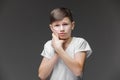 Child toothache. holding his cheek, dental pain. Closeup portrait boy with sensitive tooth. isolated grey wall background. Royalty Free Stock Photo