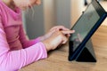 A child touches the screen of a tablet, types a text or message, searches for information on the Internet