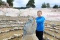 Child touching face carved in stone