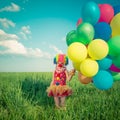 Child with toy balloons in spring field Royalty Free Stock Photo