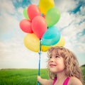 Child with toy balloons in spring field Royalty Free Stock Photo