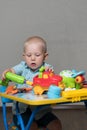 A child with toy pliers and drill repairs cars