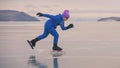 The child train on ice professional speed skating. The girl skates in the winter in sportswear, sport glasses, suit