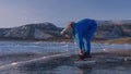 The child train on ice speed skating. Athlete puts on skates. The girl skates in the winter in sportswear, sport glasses