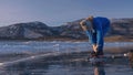 The child train on ice speed skating. Athlete puts on skates. The girl skates in the winter in sportswear, sport glasses