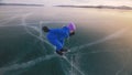 The child train on ice speed skating. The athlete at the start, in a sports stance. The kid girl skates in the winter in