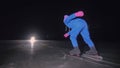 The child train on ice speed skating. The night skating. The girl skates in the winter in sportswear, sport glasses