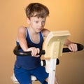 The child is trained on a stationary bike . Healthy lifestyle. Royalty Free Stock Photo