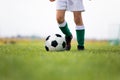 Child training soccer on fresh grass pitch. Low angle close-up image of soccer training