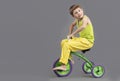 The child on a tricycle on a gray background. Royalty Free Stock Photo