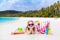 Child at tropical beach with bag and toys. Royalty Free Stock Photo