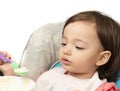 Child trying to eat food with spoon in baby highchair. eating training on chair