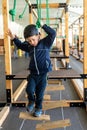 Child trying to overcome the obstacles of an adventure park