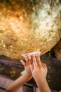 A child is trying to paste a gold sheet on round stones buried