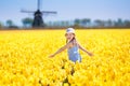 Kids in tulip flower field. Windmill in Holland