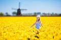 Kids in tulip flower field. Windmill in Holland Royalty Free Stock Photo