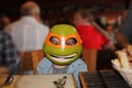 Child in Turtle Mask at a Table