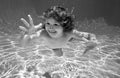 Child underwater. Funny face portrait of child boy swimming and diving underwater with fun in pool. Royalty Free Stock Photo