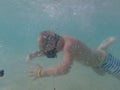 A child in an underwater mask learns to swim and dive. The boy dives into the sea Royalty Free Stock Photo