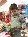 Child with unfold book in a bookstore Royalty Free Stock Photo