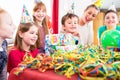 Child unwrapping birthday gift with friends Royalty Free Stock Photo