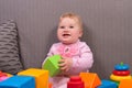 Child up to a year playing in cubes, laughs