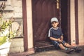 Child boy punished sad boring sitting lonely on door steps