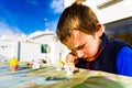 Child uses his free time as a hobby painting plaster pieces outdoors