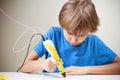 Child using 3D printing pen. Boy making new item. Creative, technology, leisure, education concept Royalty Free Stock Photo