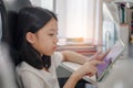 Child using gadgets to study. Schoolgirl doing her homework with digital tablet at home. Education and distance learning for kids Royalty Free Stock Photo