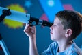 Child using telescope to watch galaxy