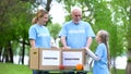 Child volunteer talking to family, fruits and canned food with donation boxes