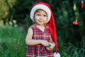 Child waiting for a Christmas in wood in juli. portrait of little children near christmas tree. girl decorating christmas tree Royalty Free Stock Photo