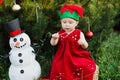 Child waiting for a Christmas in wood in juli. portrait of little children near christmas tree. girl decorating christmas tree Royalty Free Stock Photo