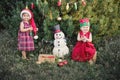 Child waiting for a Christmas in wood in juli. portrait of little children near christmas tree. girl decorating christmas tree Royalty Free Stock Photo