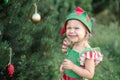 Child waiting for a Christmas in wood in juli. portrait of little children near christmas tree. girl decorating christmas tree Royalty Free Stock Photo