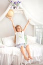 Child wakes up in morning in bed and stretches. Lazy girl happy waking up in bed rising hands to window in morning with feeling re Royalty Free Stock Photo