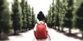 Child walking down a tree-lined path with a red backpack Royalty Free Stock Photo