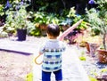 Child walking in the garden with pink umbrella on sunny weather Royalty Free Stock Photo