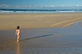 Child walking towards ocean