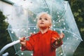 Child walking with umbrella outdoor autumn season kid wearing red raincoat rainy weather Royalty Free Stock Photo