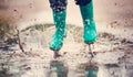 Child walking in wellies in puddle on rainy weather