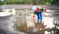 Child walking in wellies in puddle on rainy weather