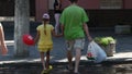 Child walks with daddy and pulls red balloon. Promoters give gifts to all buyers