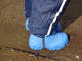 The child walks through puddles in rubber boots in the spring