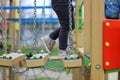 child walks on a suspended children& x27;s chain road on the playground Royalty Free Stock Photo