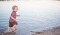 The child walks water and sand on the bank of the lake