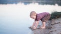 The child walks water and sand on the bank of the lake