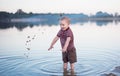 The child walks water and sand on the bank of the lake