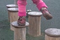 A child walks on a wooden log in a children& x27;s park, a kid overcomes obstacles, plays on a children& x27;s playground